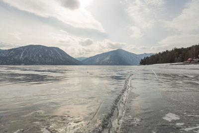 View of beautiful drawings on ice from cracks on the surface of lake teletskoye in winter, russia