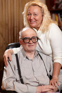 Portrait of happy woman with senior man at home