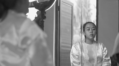 Sad young woman reflecting on mirror