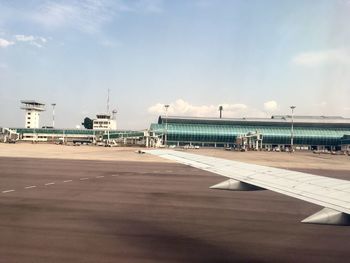 Airplane on airport runway against sky