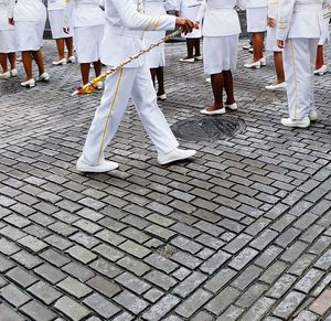 Low section of people standing on cobblestone street