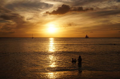 Scenic view of family watching sky during sunset 