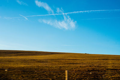 Scenic view of field against blue sky