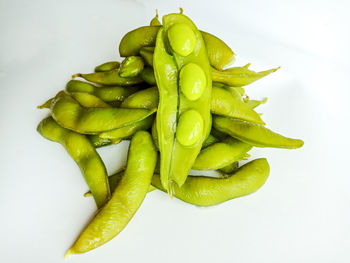 Close-up of green chili pepper against white background