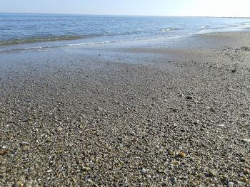 Surface level of sandy beach against clear sky