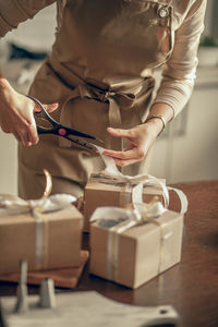 Woman bakery shop owner cuts the ribbon on box for customer order. entrepreneur, food delivery