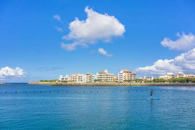 Man doing paddle surfing in the hamakawa fishing port in the chatan city beach in okinawa.