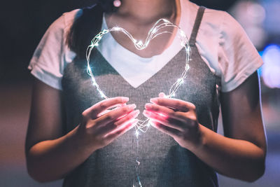 Close-up of woman holding heart shape