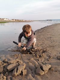 Full length of boy on beach against sky