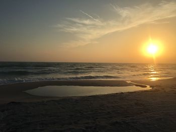 Scenic view of beach against sky during sunset