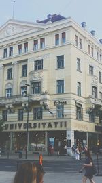 People walking on street in city against sky