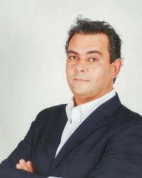 Close-up portrait of confident businessman against white background