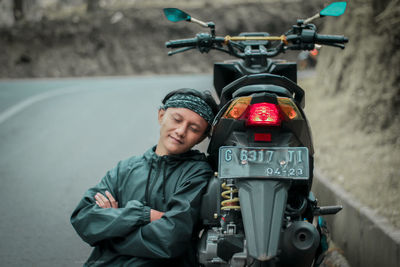 Portrait of man with bicycle standing on road