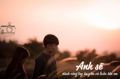 People looking at camera against sky during sunset