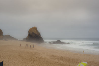 People on beach against sky