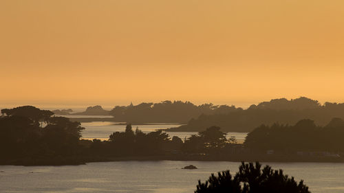 Scenic view of lake against orange sky
