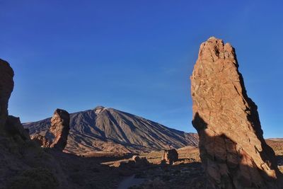 Scenic view of mountains against clear blue sky