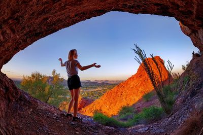 Rear view of woman standing on rock