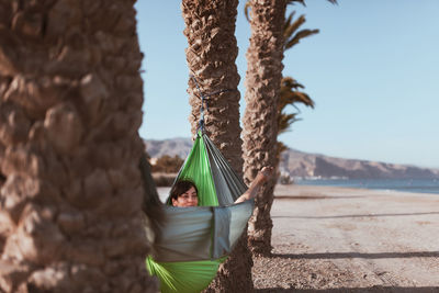 Smiling woman relaxing on hammock