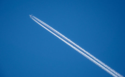 Low angle view of vapor trail against blue sky
