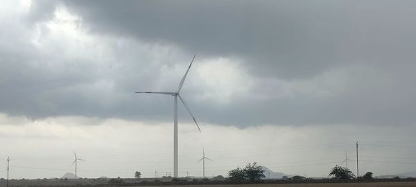 Low angle view of windmills against sky