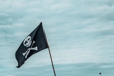 Low angle view of pirate flag against the sky