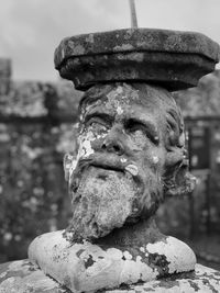 Close-up of bust statue against stone wall
