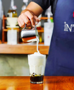 Man pouring drink on table