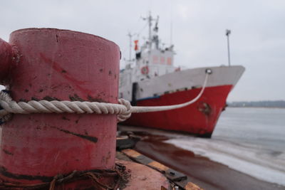 Close-up of rope tied to moored on beach