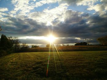 Scenic view of grassy field against cloudy sky