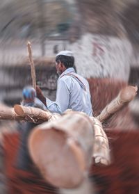 Rear view of men sitting on wood