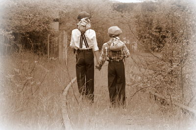 Rear view of men walking on field