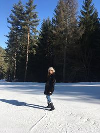 Portrait of young smiling woman walking on snow covered landscape 