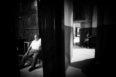 Rear view of people sitting on chair in building