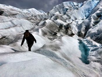 Woman walking on snow covered landscape