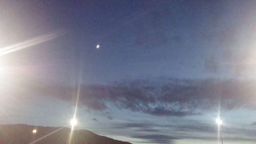 Low angle view of illuminated street light against sky