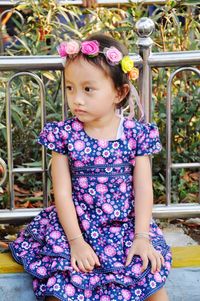 Portrait of cute girl sitting on purple flowering