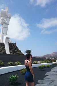 Woman standing in city against sky