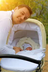 Father dressing son sleeping in crib