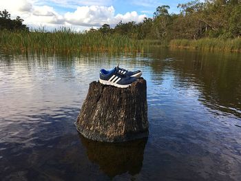 Boat moored on lake against sky