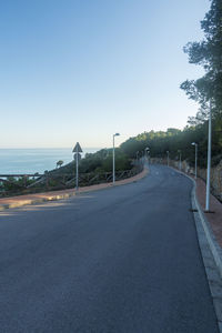 Empty road against clear blue sky