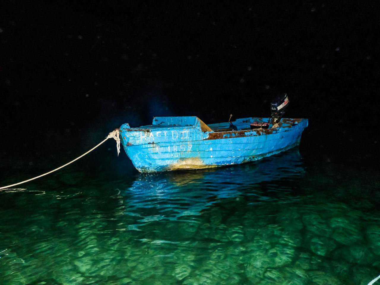 BOAT MOORED IN SEA