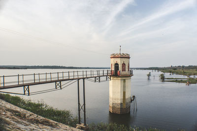 Lighthouse by sea against sky