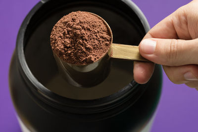 High angle view of person hand holding ground food in spoon