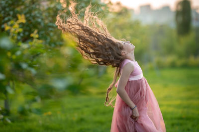 Side view of woman standing against plants