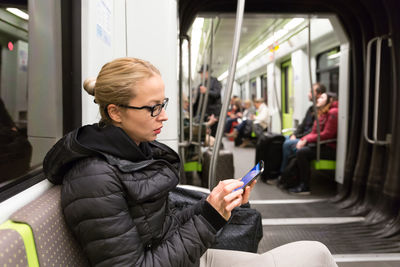 Young man using mobile phone while sitting in train