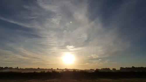 Scenic view of field against sky at sunset