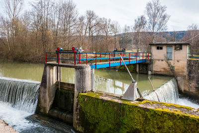 Built structure by river against sky