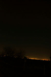 Silhouette landscape against sky at night