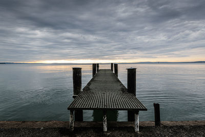 Pier over sea against sky during sunset